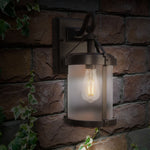Outdoor wall light fixture on a stone wall with a warm glow.
