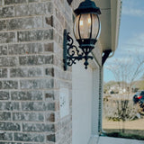 Outdoor light fixture on a brick wall with a blurred background