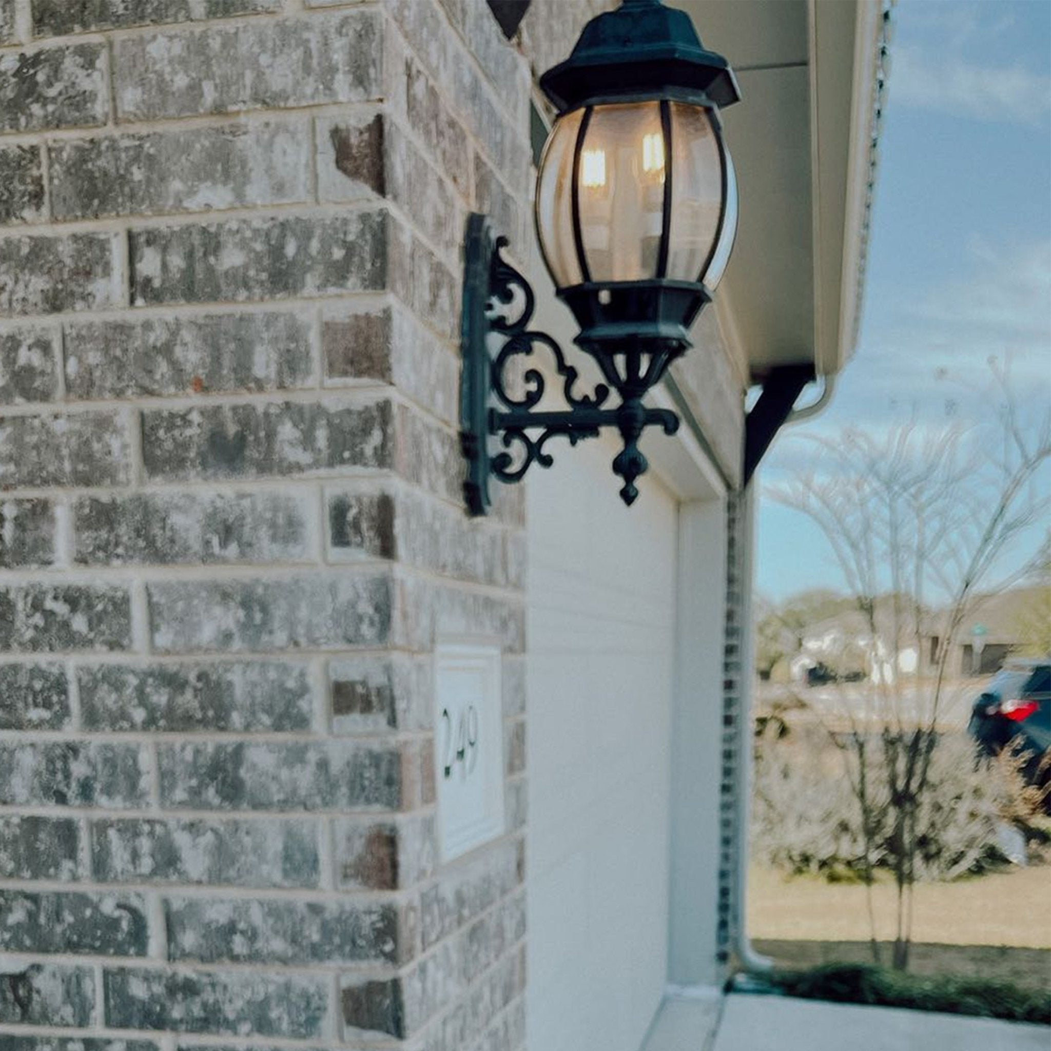 Outdoor light fixture on a brick wall with a blurred background